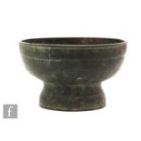 A Chinese Archaic style cast metal pedestal censer, raised on a domed base, extending to a deep