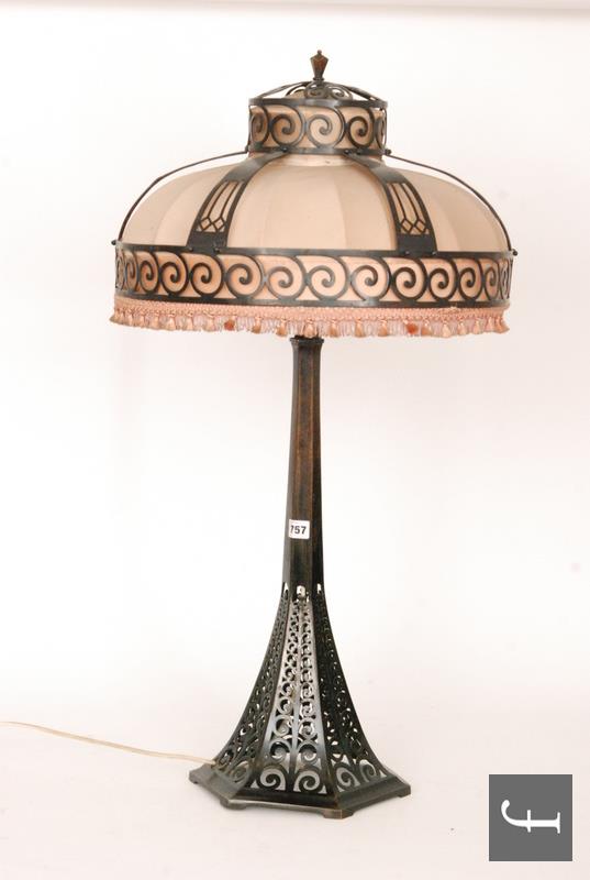 An Art Deco bronze table lamp, the hexagonal swept base with pierced scroll decoration rising to a