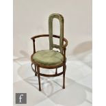 An Arts and Crafts stained beech hoop back elbow chair, the curved arm rail over an oval seat and