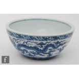 A Chinese blue and white bowl, the heavily potted bowl, adorned with two five-clawed dragons, set