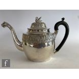 A late 19th Century low grade silver boat shaped tea pot with a stiff leaf border, lion head