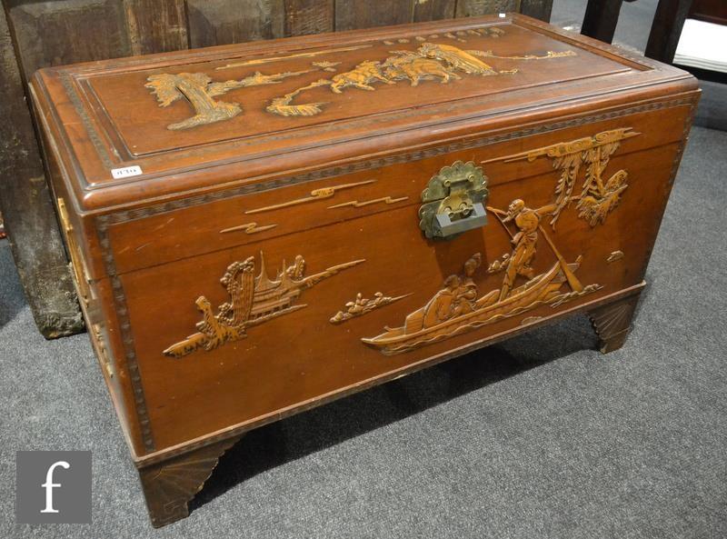 A 20th Century carved camphorwood coffer with raised design detailing goats, figures and landscape