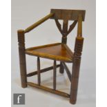 A late 19th Century oak and ash Warwick Turners chair, bobbin arms over a plank seat on turned
