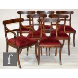 Seven William IV mahogany yoke back dining chairs with sabre front legs, including six standard