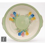 A Clarice Cliff cake plate decorated in the Spring Crocus pattern, gilt script Newport mark,