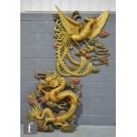 Two Chinese painted wooden wall carvings, the first modelled as a five-clawed dragon holding the