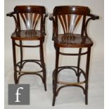 A pair of stained beech bentwood counter chairs in the manner of Thonet, with pierced fan backs on
