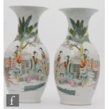 A pair of Chinese famille rose vases, of baluster form, rising to a flared rim, painted in mirror