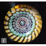 A 1970s Whitefriars glass paperweight, with concentric rings of millefiori ruffle and cog canes in