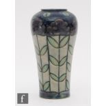 An early 20th Century Royal Doulton stoneware vase decorated with purple long stem flowers,