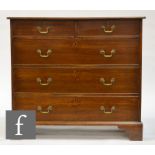 A George III chest of two short over three long drawers, with brass drop handles over bracket feet.