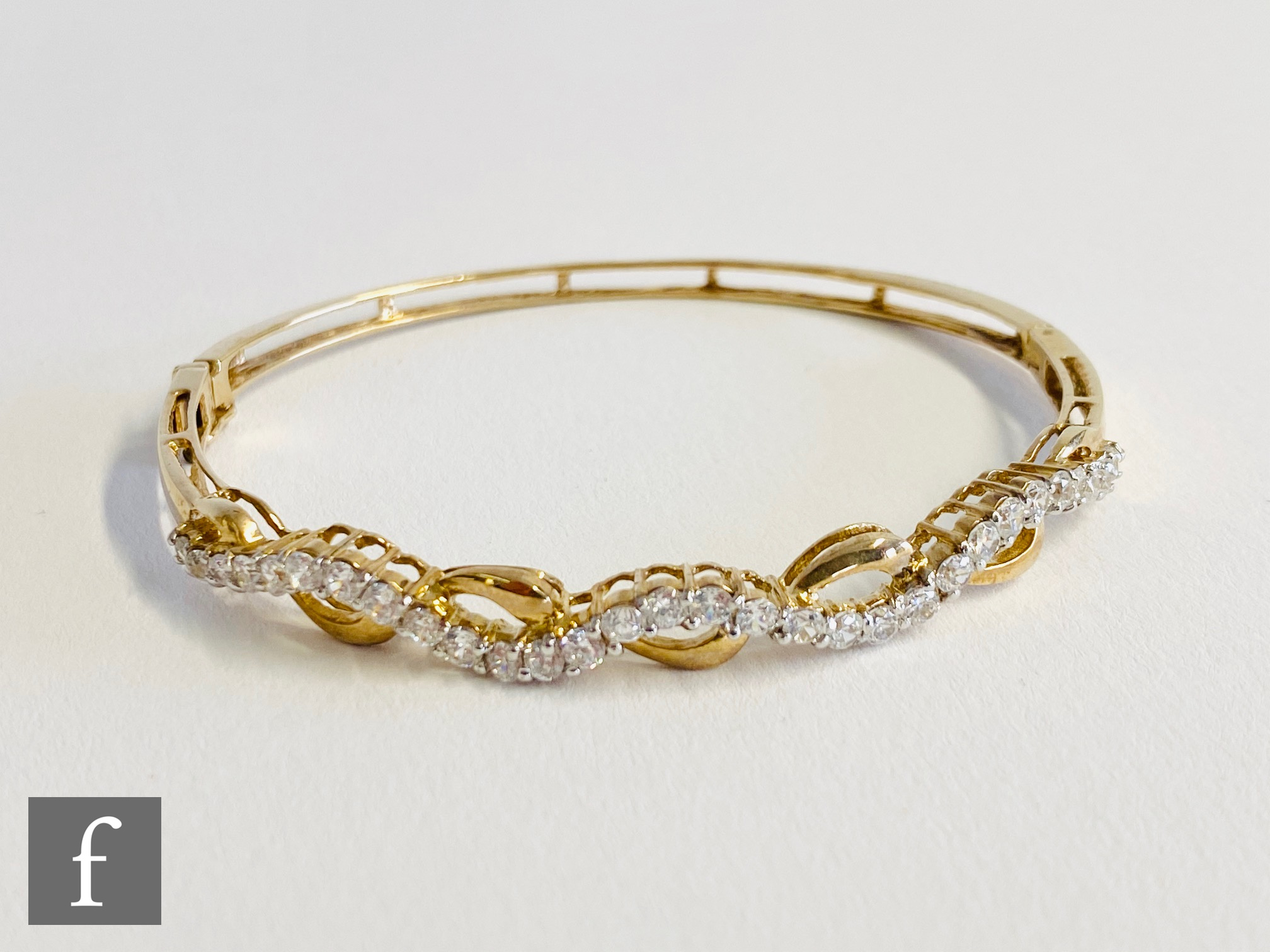 A modern 9ct hallmarked bangle set with a single row of cubic zirconia, total weight 9.5g.