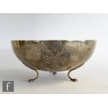 A low grade silver circular bowl with embossed double headed eagle and a lion, all raised on three