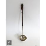 A 19th Century white metal double lipped ladle terminating in turned fruitwood handle, length 38cm.