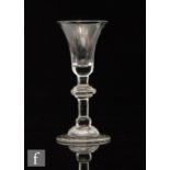 An 18th Century composite drinking glass circa 1725, bell form bowl with medial annulated knop to