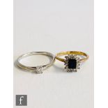 A 9ct hallmarked sapphire and diamond cluster ring, central emerald cut sapphire within a diamond