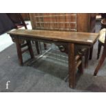 A Chinese hardwood low bench, the single plank top raised on four splayed supports,