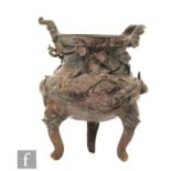 A Chinese bronze tripod censer, rising from three zoomorphic supports with taotie mask design, the
