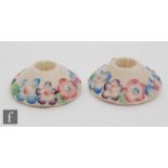 A pair of Clarice Cliff My Garden pattern candlesticks, each of compressed form with a band of