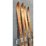 A pair of early 20th Century skis by Hofbauer wooden line decoration, metal mounts, length 198cm and