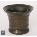 A small 18th Century bronze mortar height 10cm and a brass chamberstick, height 11cm (2)