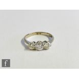 A 1930's 18ct white gold three stone diamond ring, three transitional brilliant cut stones to