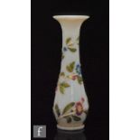 A 19th Century Baccarat opaline vase, of footed slender skittle form with flared rim, relief moulded