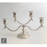 A hallmarked silver squat four light candelabra, circular base with reeded detail below three scroll