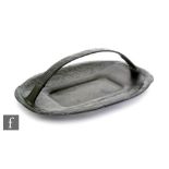 A Liberty & Co Tudric pewter cushioned oval tray with single arched handle with repeat stylised seed
