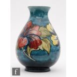 A Moorcroft baluster vase decorated in the Hibiscus pattern with a band of coloured flowers