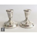 A pair of hallmarked silver squat candlesticks, circular bases with reeded detail below conforming