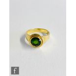 An 18ct single stone green tourmaline ring, central circular collar set stone within a plain gold