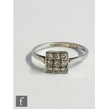 An early 20th Century platinum diamond nine stone floodlight ring, transitional cut stones to