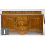 An 18th Century oak dresser, fitted with three central drawers flanked by a pair of fielded panel