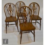 A set of four beech and elm seated wheel back dining chairs (4)