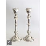 A pair of hallmarked silver candlesticks, circular bases with reeded details below conforming knop