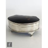 A hallmarked silver and tortoise shell trinket box, the plain silver body raised on four scroll legs