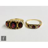 An early 20th Century 18ct ruby and diamond five stone boat shaped ring with a later 9ct garnet
