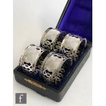 A cased set of four hallmarked silver circular pierced napkin rings, Birmingham 1907, Henry