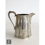 A Victorian hallmarked silver cream jug of slender form with aesthetic foliate engraved