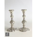 A pair of hallmarked silver piano candlesticks circular bases and knopped columns with fluted