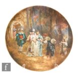 A late 19th to early 20th Century charger decorated with two ladies and a gentleman in Tudor