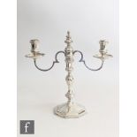 A hallmarked silver twin light candelabra, stepped hexagonal base below knop column, scroll arms and