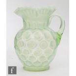 A 20th Century Fenton glass jug of ovoid form with frill rim and applied handle, decorated in a dot