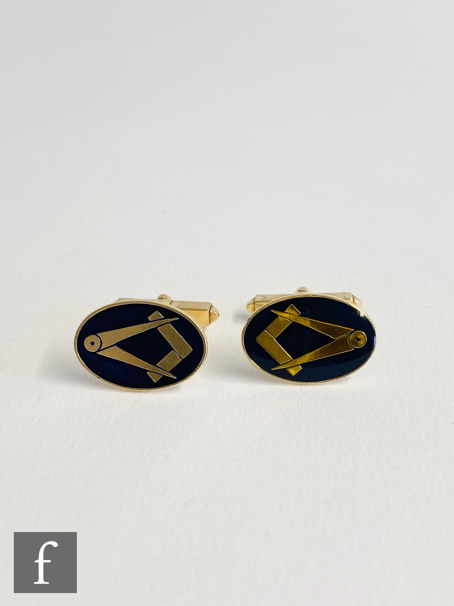 A pair of 9ct hallmarked oval swivel cufflinks with Masonic set square and compass to a blue ground