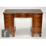 A 'Reprodux' George III style mahogany kneehole desk with leather inset top over a frieze drawer