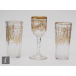 A pair of French glass beakers of faceted form decorated with gilded swags and foliage, height 13cm,