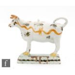 An early 19th Century pearlware cow creamer and cover, she decorated with tan wavy lines and black