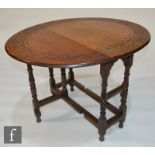 A small early 20th Century carved oak gate-leg tea table, with an acanthus border above the