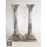 A pair of hallmarked silver Corinthian column candlesticks of typical form, heights 25cm, Birmingham